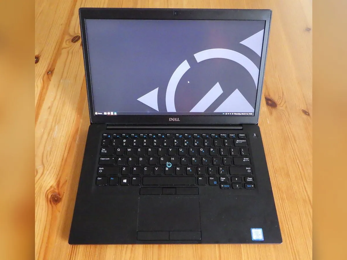 Ordinateur portable Dell Latitude ouvert sur une table en bois, vu de dessus